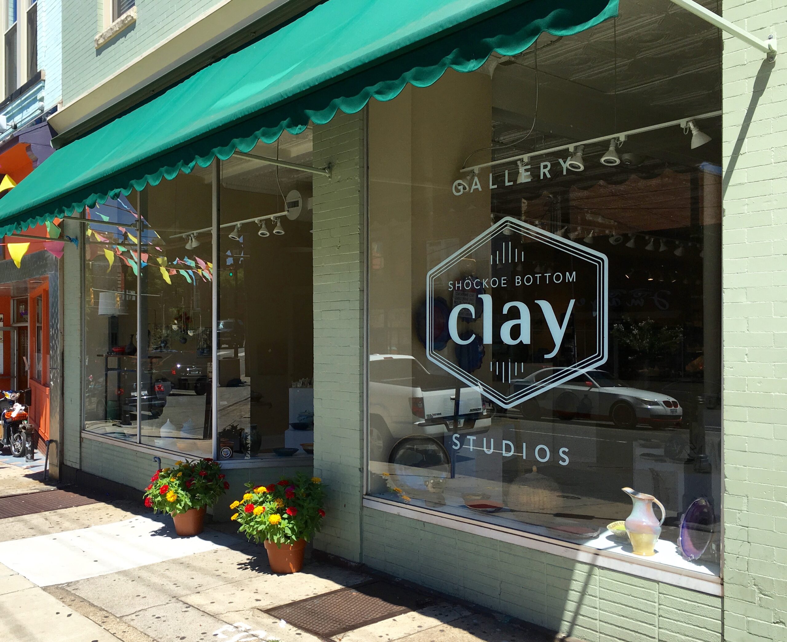 A Variety Of Colorful Clay Pots And Vases Arranged Attractively In A Store Window Display.